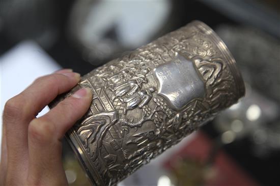 A mid-19th century Chinese silver mug, the body featuring warriors fighting to one side, with inscribed shield plaque H.13cm.